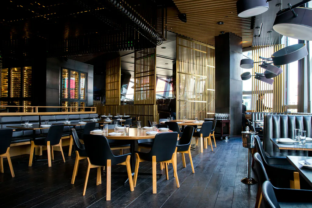 Beleuchteter Restaurant-Innenraum mit gedeckten Tischen am Abend